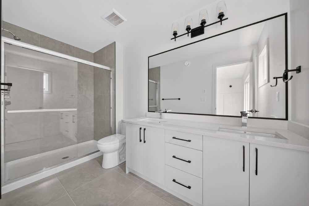Primary ensuite with double vanity and tiled shower